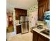 View of the kitchen with stainless steel refrigerator and stove, showcasing the layout and vintage design at 1818 Brookrun Rd, Henderson, NC 27536