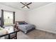 Bright carpeted bedroom featuring a ceiling fan, a desk and a window at 1828 Wellspring Ct, Graham, NC 27253