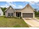 Charming single-story home featuring a mix of brick and vinyl siding, a two-car garage, and well-maintained landscaping at 1828 Wellspring Ct, Graham, NC 27253