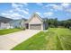 Side view of a one-story home featuring a green lawn and a two-car garage with extended driveway at 1828 Wellspring Ct, Graham, NC 27253