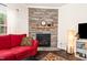 Inviting living room featuring a stone fireplace and comfortable red sofa, perfect for relaxation at 1828 Wellspring Ct, Graham, NC 27253
