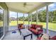Relax in a bright sunroom with plush seating, a ceiling fan, and picturesque backyard views at 1828 Wellspring Ct, Graham, NC 27253