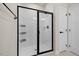 Bathroom with a modern glass shower, sleek black hardware, and white tiled walls at 2006 Nola Ln, Durham, NC 27713