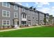 Well-maintained gray townhomes showcase manicured lawns and inviting front doors at 2006 Nola Ln, Durham, NC 27713