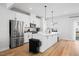 Modern kitchen features stainless steel appliances, a center island, and sleek white cabinetry at 2006 Nola Ln, Durham, NC 27713