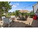 This backyard features a stone patio with seating, umbrella, grill, and landscaping at 2127 Somers Ave, Burlington, NC 27215