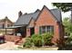 Attractive brick home with a cozy covered porch, surrounded by mature landscaping and a welcoming entrance at 2210 Hope St, Raleigh, NC 27607