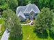Aerial view of brick home on a large lot with mature trees and manicured landscaping at 225 Midenhall Way, Cary, NC 27513
