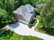 Aerial view of a well-manicured property, mature trees, a driveway, and a three-car garage at 225 Midenhall Way, Cary, NC 27513
