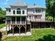 Back exterior featuring a deck, screened-in porch, and a well-maintained yard at 225 Midenhall Way, Cary, NC 27513