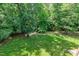 A well-maintained, grassy backyard surrounded by lush green trees at 225 Midenhall Way, Cary, NC 27513