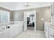Large luxury bathroom with dual vanities, marble tile, soaking tub and an entrance to the Primary bedroom at 225 Midenhall Way, Cary, NC 27513