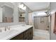 Bathroom with double sinks, stylish dark cabinets, modern lighting, tub and shower at 225 Midenhall Way, Cary, NC 27513