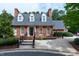 Exterior of the clubhouse features a brick facade, landscaped garden, and covered entry at 225 Midenhall Way, Cary, NC 27513