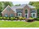 Charming brick home with lush landscaping, a manicured lawn, and striking curb appeal at 225 Midenhall Way, Cary, NC 27513