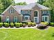 Beautiful brick home featuring manicured landscaping, blue shutters, and a grand two-story entrance at 225 Midenhall Way, Cary, NC 27513