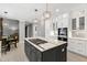 Bright kitchen features an island with cooktop, modern appliances, white cabinets, and pendant lighting at 225 Midenhall Way, Cary, NC 27513