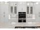 Bright kitchen features white cabinets, stainless steel appliances and sleek hardware against a decorative backsplash at 225 Midenhall Way, Cary, NC 27513