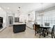 Bright kitchen features modern appliances, pendant lighting, white cabinets, and an island with seating and quartz countertops at 225 Midenhall Way, Cary, NC 27513