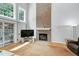 Living room featuring a brick fireplace, ample natural light from large windows, and hardwood floors at 225 Midenhall Way, Cary, NC 27513