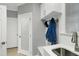 Practical mud room with sink, cabinets, hooks, and bench for organization at 225 Midenhall Way, Cary, NC 27513