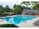 Outdoor community swimming pool with lounge seating and mature trees at 225 Midenhall Way, Cary, NC 27513