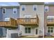 Rear exterior of townhomes showcasing private wood decks, white fencing, and green lawn at 2299 Bay Minette Sta # 537, Apex, NC 27502