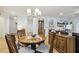 Bright dining area featuring a chandelier, hardwood floors, and an adjacent living space with fireplace at 2410 Kinglass Dr, Fuquay Varina, NC 27526