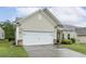 Attractive home with stone detailing, lush landscaping, and a two-car garage at 2410 Kinglass Dr, Fuquay Varina, NC 27526