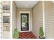 Charming entryway featuring a patterned rug, stylish door, and manicured greenery at 2410 Kinglass Dr, Fuquay Varina, NC 27526