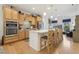Well-lit kitchen featuring a large island with seating, stainless steel appliances, and wooden cabinets at 2410 Kinglass Dr, Fuquay Varina, NC 27526