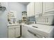 Functional laundry room with a utility sink, white cabinetry, washer, dryer, and laundry supplies at 2410 Kinglass Dr, Fuquay Varina, NC 27526