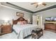 Well-lit main bedroom with a tray ceiling, neutral decor, with a view of an ensuite bathroom at 2410 Kinglass Dr, Fuquay Varina, NC 27526