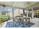 Inviting sunroom featuring a ceiling fan, comfortable seating, and a vibrant blue rug with leafy patterns at 2410 Kinglass Dr, Fuquay Varina, NC 27526