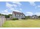 Spacious fenced backyard featuring a stone fire pit, lush green grass, and a well-maintained lawn at 2507 Belvinwood Dr, Fuquay Varina, NC 27526