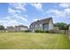Expansive, fenced backyard with lush grass, showcasing a stone fire pit and neighboring properties at 2507 Belvinwood Dr, Fuquay Varina, NC 27526