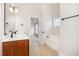 Bright bathroom featuring double sinks, wood cabinets, tile floors, soaking tub, and natural light at 2507 Belvinwood Dr, Fuquay Varina, NC 27526