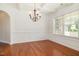 Formal dining room with hardwood floors, elegant chandelier, wainscoting and large window at 2507 Belvinwood Dr, Fuquay Varina, NC 27526