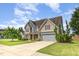 Two-story home featuring a manicured lawn, attached garage, and inviting front porch and long driveway at 2507 Belvinwood Dr, Fuquay Varina, NC 27526