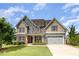 Charming two-story home featuring a manicured lawn, attached garage, and inviting front porch at 2507 Belvinwood Dr, Fuquay Varina, NC 27526