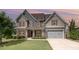Charming two-story home featuring a manicured lawn, attached garage, and inviting front porch at 2507 Belvinwood Dr, Fuquay Varina, NC 27526