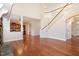 Spacious living room with hardwood floors, staircase with white wooden railing, and an open kitchen at 2507 Belvinwood Dr, Fuquay Varina, NC 27526