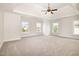 Spacious main bedroom with neutral carpet, tray ceiling, and multiple large windows at 2507 Belvinwood Dr, Fuquay Varina, NC 27526