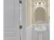 Powder room with a pedestal sink, decorative mirror, and wainscoting at 2513 Asher View Ct, Raleigh, NC 27606