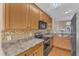 Well-lit kitchen featuring wood cabinets, stainless appliances, and tile backsplash at 2513 Asher View Ct, Raleigh, NC 27606