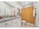 Bathroom with a large mirror, granite countertop, white vanity, and patterned shower curtain at 2620 Holloway St, Durham, NC 27703