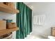 Stylish bathroom with a green curtain, open shelves, and white towels at 2620 Holloway St, Durham, NC 27703