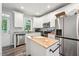Modern kitchen featuring white cabinets, granite countertops, stainless steel appliances, and a central island at 2620 Holloway St, Durham, NC 27703