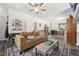 Open-concept living room with stylish furnishings, a ceiling fan, and dark wood-look flooring at 2620 Holloway St, Durham, NC 27703