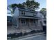 Side view of a gray, two-story home featuring modern design and a cozy, covered front porch at 2658 Lawndale Ave, Durham, NC 27705